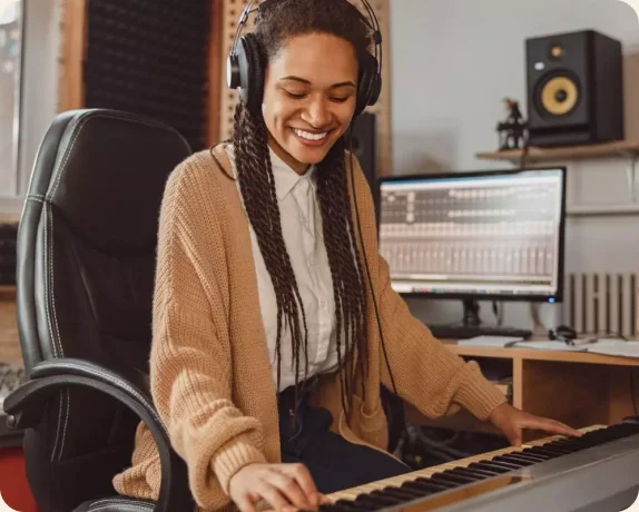 Person wearing headphones playing electronic piano