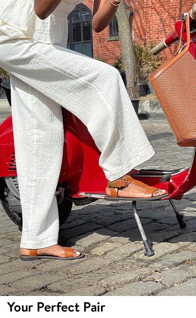 A woman wearing flat sandals and a woman wearing low heels.