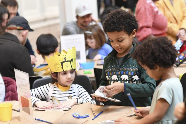 Children making art, one wearing a handmade yellow crown