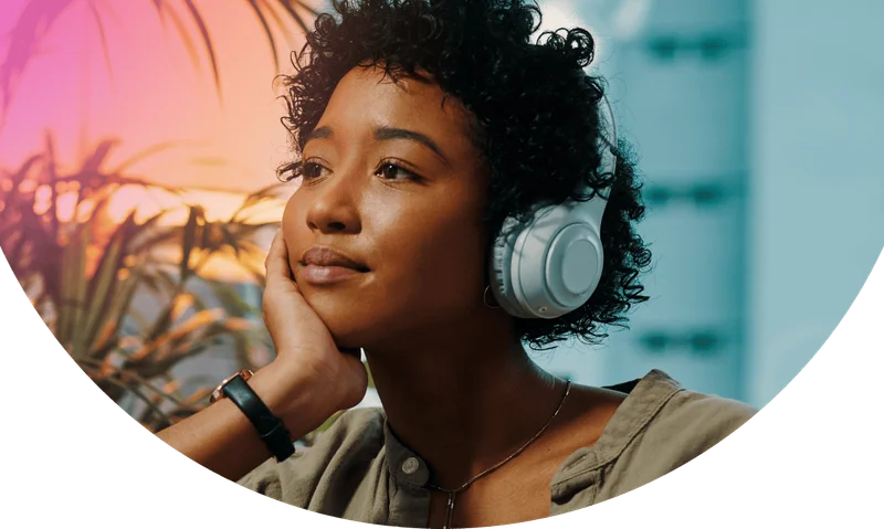 Shot of a young woman wearing headphones while sitting at home with her laptop