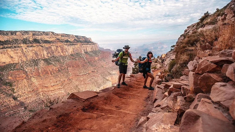 Image description: Two hikers on trail at Grand Canyon National Park’s South Rim.