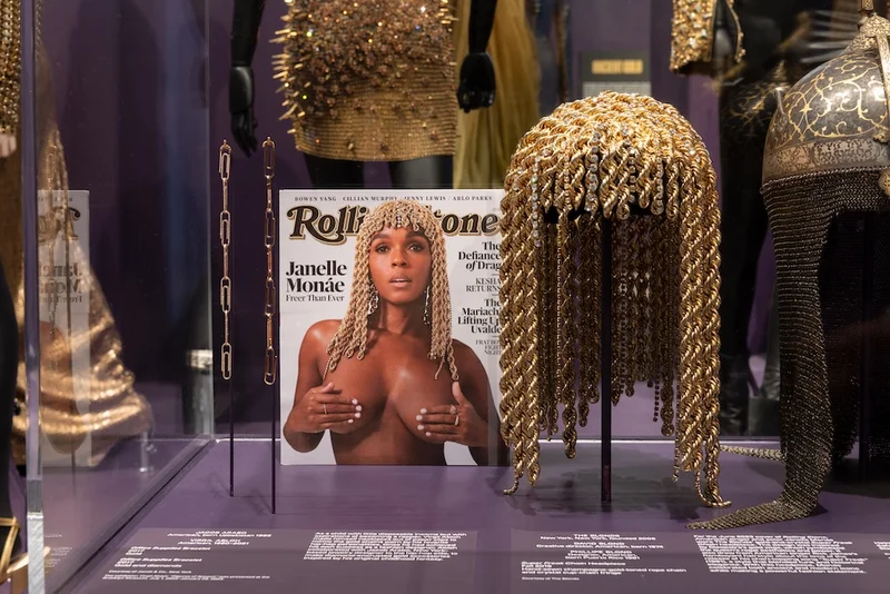 Display of a gold headpiece and a magazine cover on which Janelle Monáe is shown wearing it