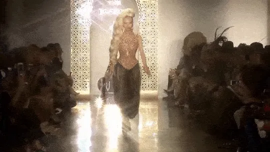 A GIF of a model strutting down a runway