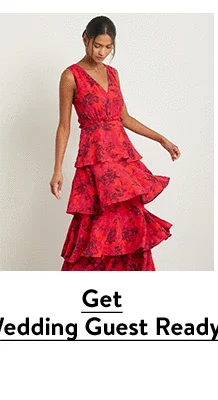 A woman wearing a red floral-print maxi dress.