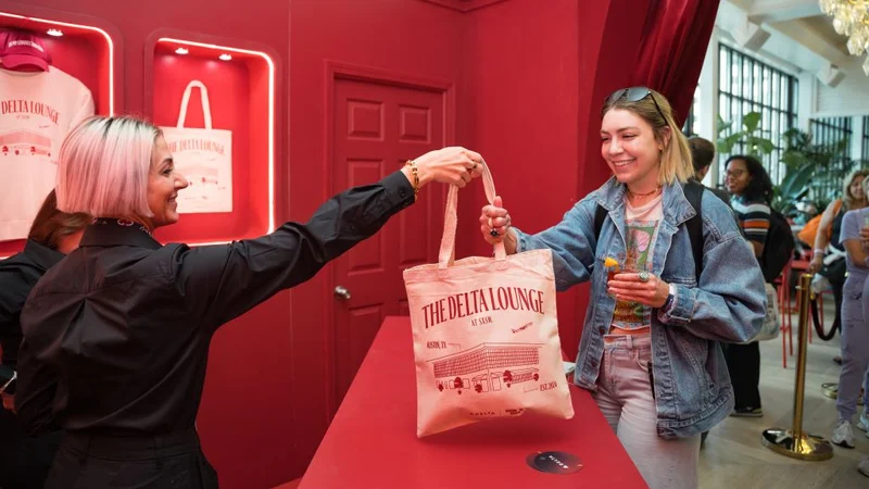 A Delta SkyMiles member picks up an exclusive tote bag at the Gifting Salon at Delta's lounge at SXSW.