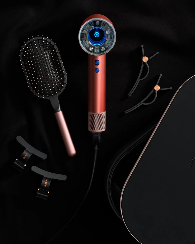 The Dyson Supersonic Nural in Strawberry bronze and blush pink with accessories.