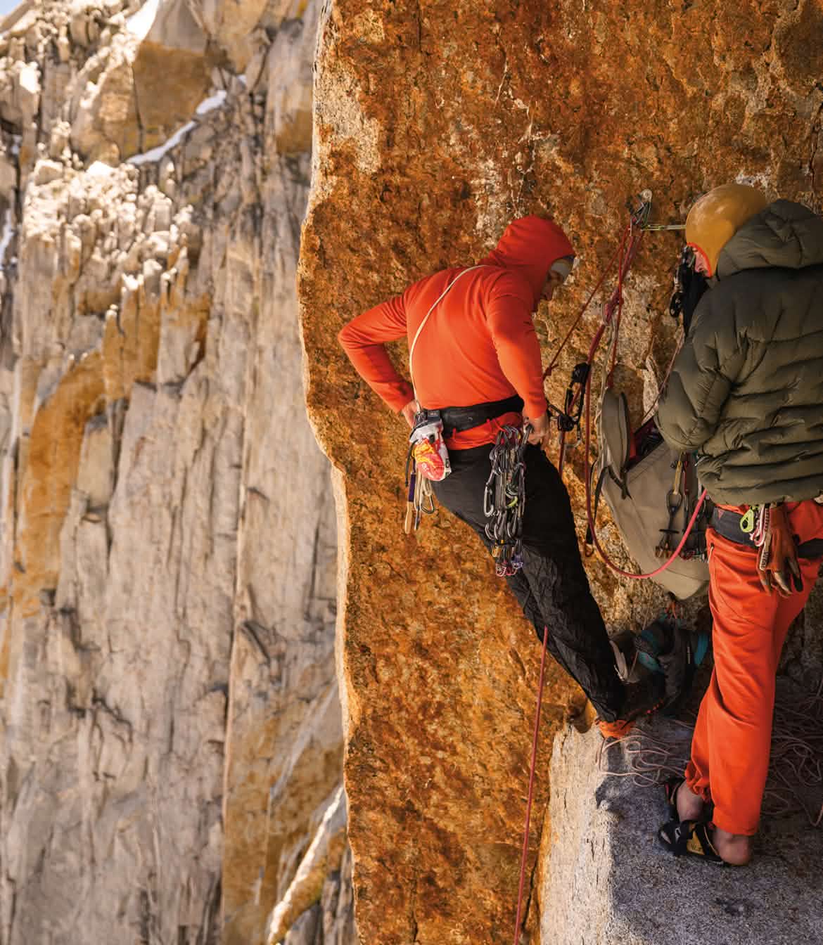 Two climbers at a belay ledge on a big wall.