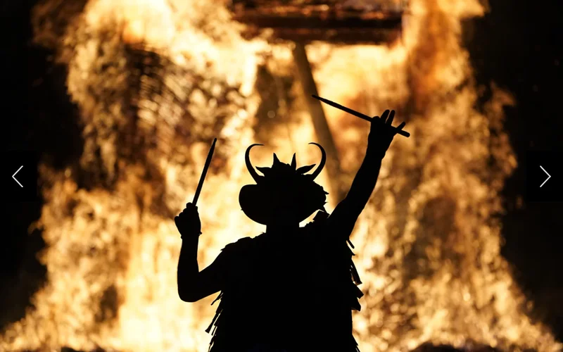 Flames rise behind a performer at the Beltane Celtic Fire Festival in southern England.