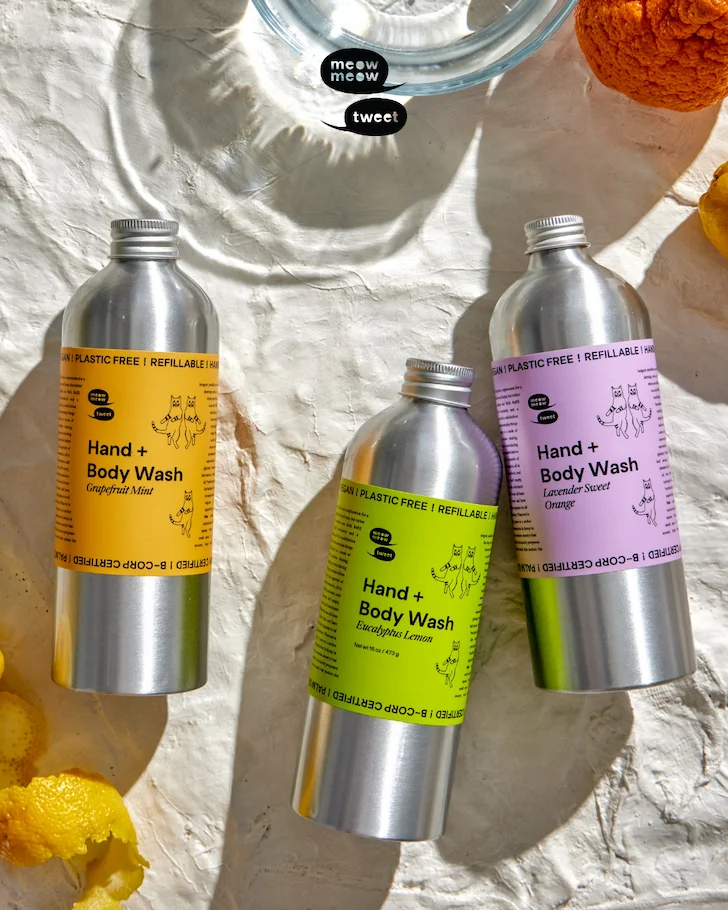 Two speech bubbles with Meow Meow Tweet over an image of three metal bottles with colorful labels
