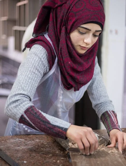 Image description: A seamstress working at a table.
