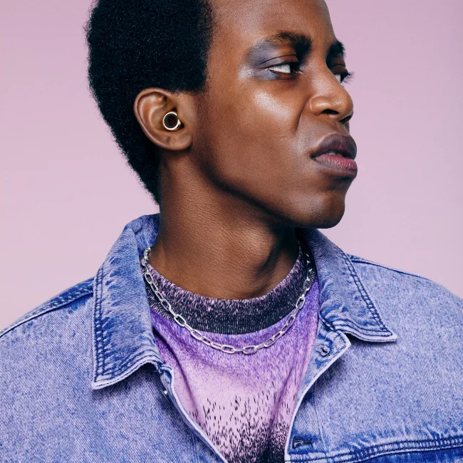 A stylish man wearing Loops looks off to the side.