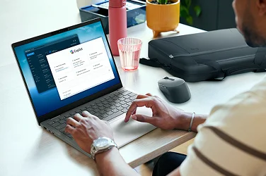 Over-shoulder view of a person working on a Dell 14 Plus computer in an office setting.