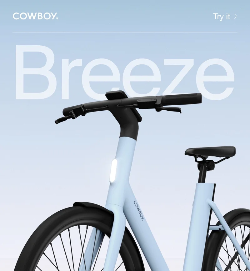 A Cowboy e-bike in the Breeze colorway, a soft blue frame with black accents, shown from a low angle against a gradient background with the word “Breeze” in large text.