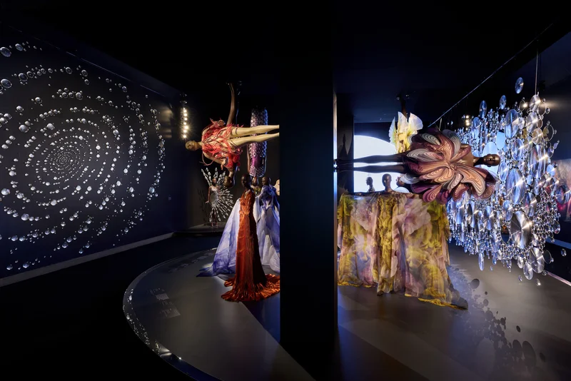 An installation with mannequins wearing colorful dresses