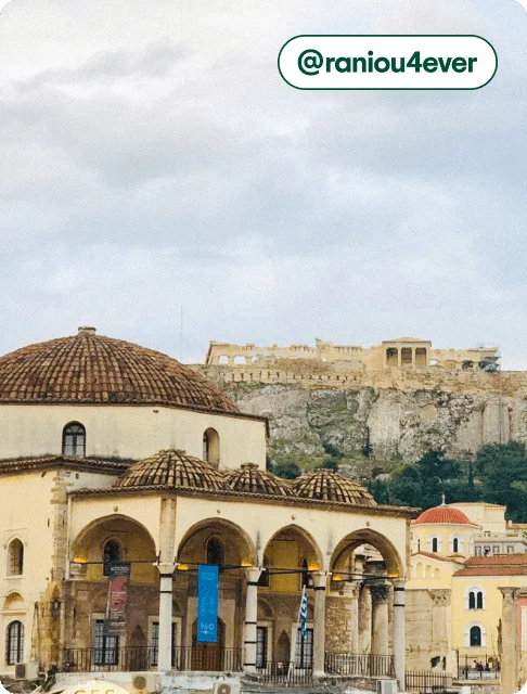 Image description: A view of domed buildings in Monastiraki Square, with the Acropolis in the distance, photo taken by @raniou4ever