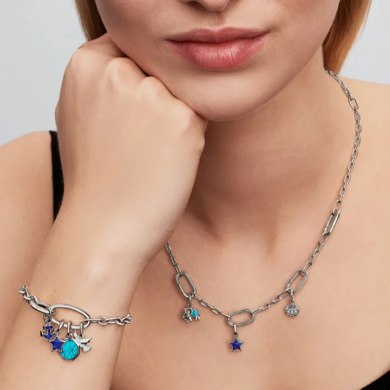 A model wears a sterling silver Pandora ME link chain bracelet and necklace with blue charms.