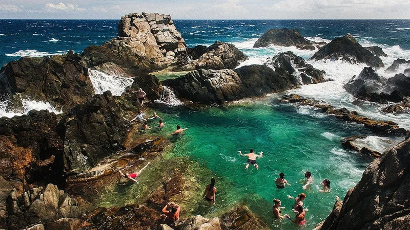 Image description: Tourists swimming in a natural pool at Arikok National Park, Aruba