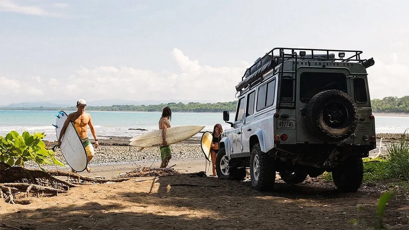 Image description: Friends unloading surfboards at beach in Costa Rica