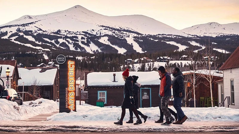 Image description: Friends walking together through the Breckenridge Arts District, in the winter