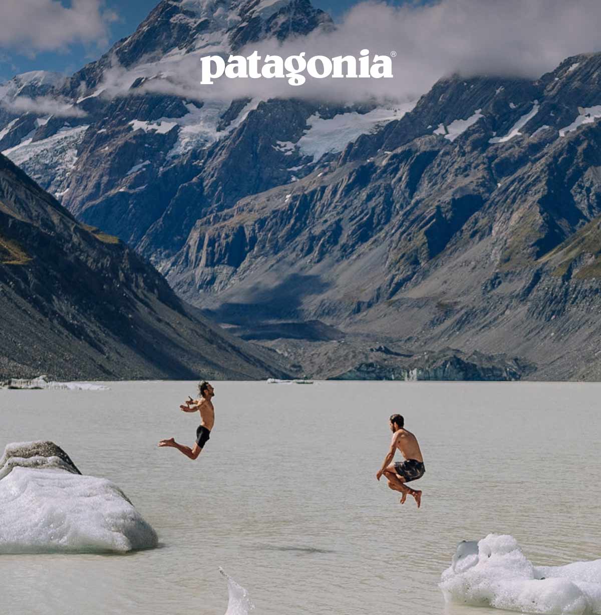 Patagonia. Two people jump off icebergs into an alpine lake.