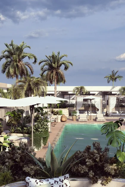 An outdoor pool surrounded by palm trees, ample foliage, and white umbrellas.