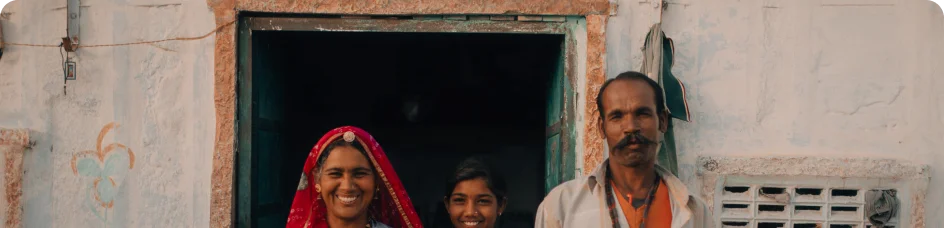 An Indian family stands in the door to their home