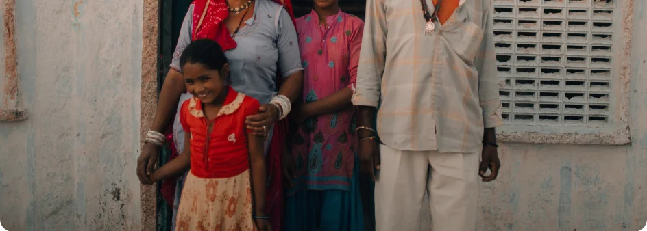 An Indian family stands in the door to their home