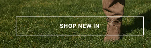 Brown suede boots on green grass. New arrivals banner for a fresh collection of stylish footwear, perfect for exploring.