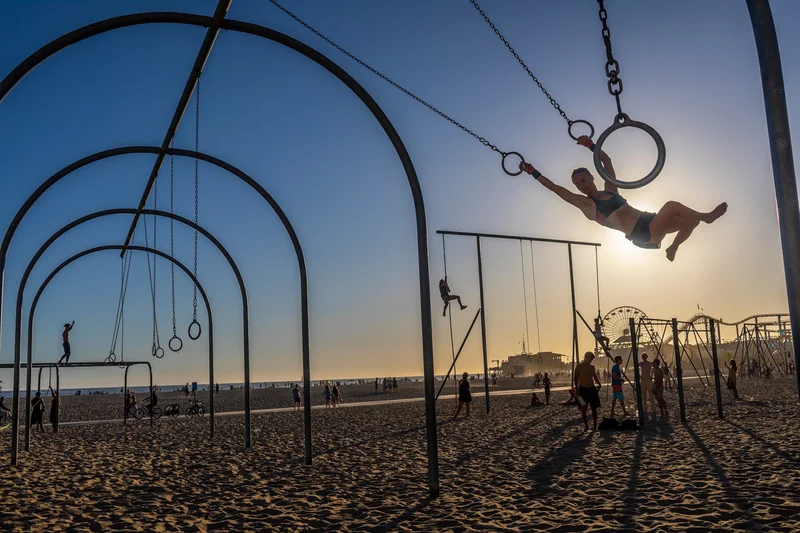 People exercise using the equipment on the beach in Santa Monica, California.