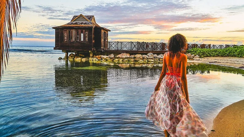 Image description: Woman walking past water at Eclipse at Half Moon, Jamaica.