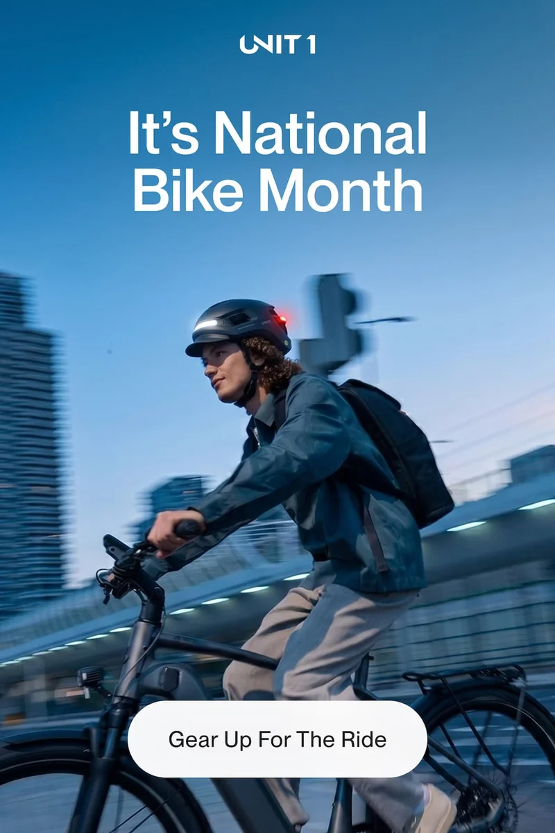 Cyclist riding in the city at dusk wearing UNIT 1 smart helmet with rear light for visibility and safety