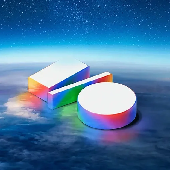 A digital art image showing three geometric shapes—a rectangular prism, a thin rectangular bar, and a cylinder—resting on a bed of clouds. The tops of the shapes are bright white, while the sides have a shimmering rainbow gradient. Above them is a dark blue, starry night sky.