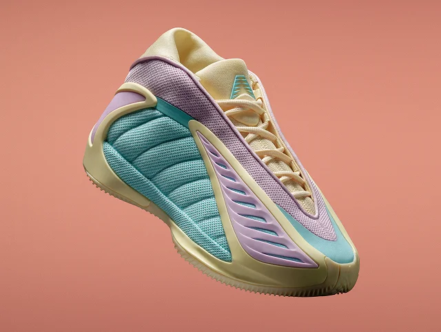 Close-up of the adidas Anthony Edwards 2 pastel basketball sneaker in lavender, teal, and yellow on an orange background.