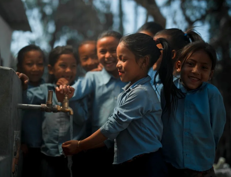 Graphic of some kids filling a cup of water from a tap.