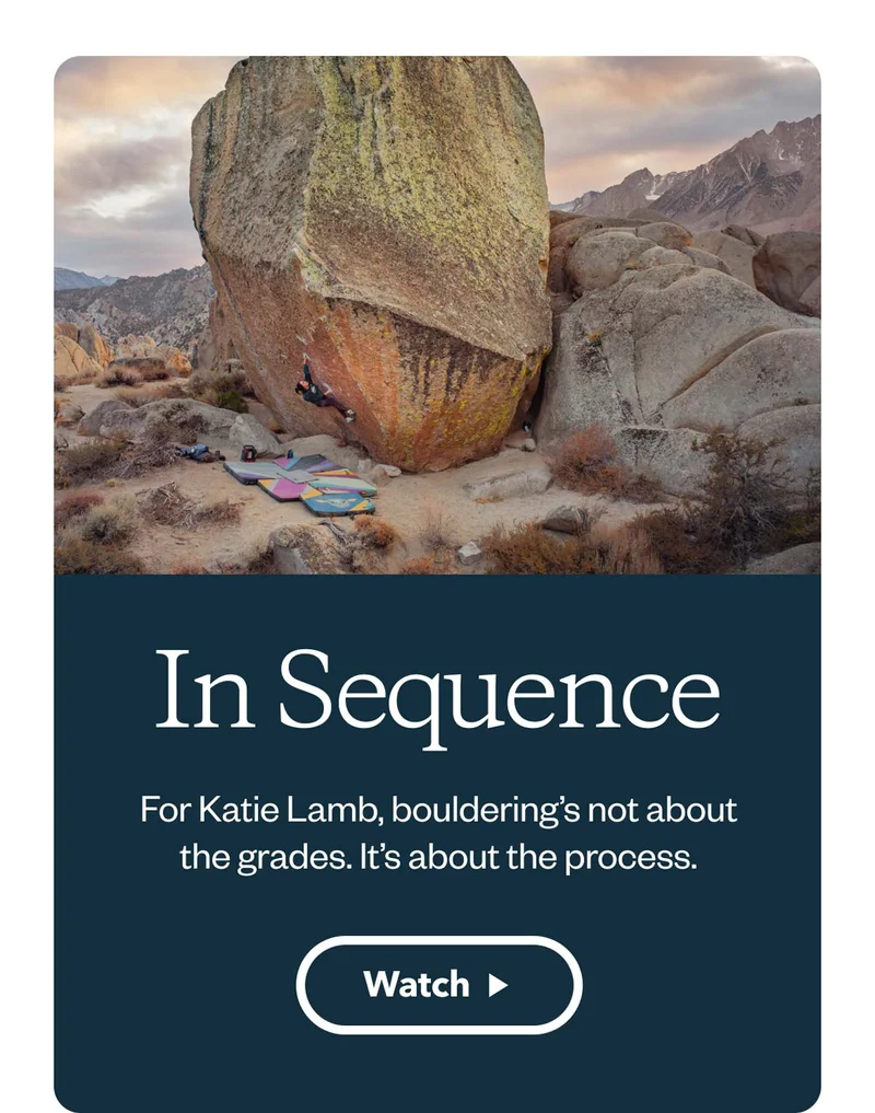 A person begins to climb an enormous boulder.
