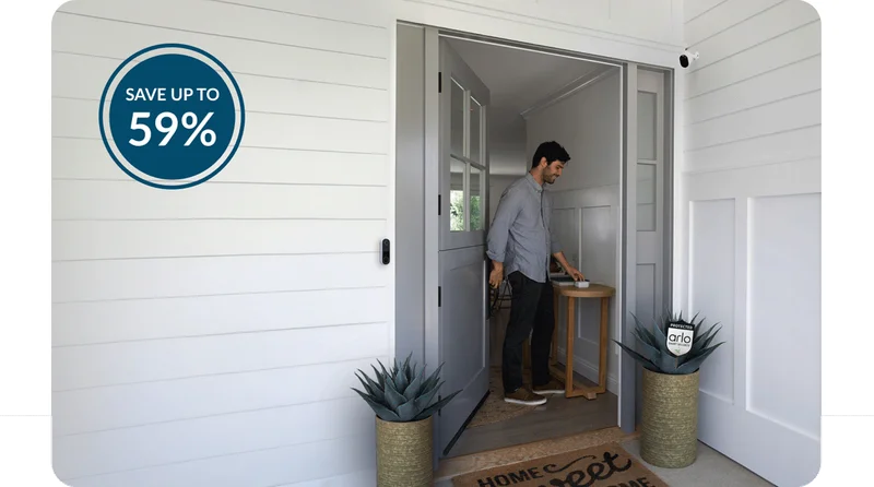 Up to 59% off. Person leaving their house through the front door as they arm the Arlo Home Security System. Various Arlo security products mounted nearby.