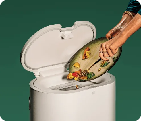 Photo of a hand scraping food scraps off a plate into Mill