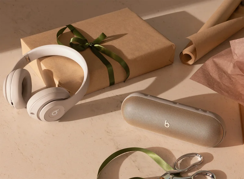Beats Studio Pro headphones and Beats Pill speaker next to a wrapped gift.