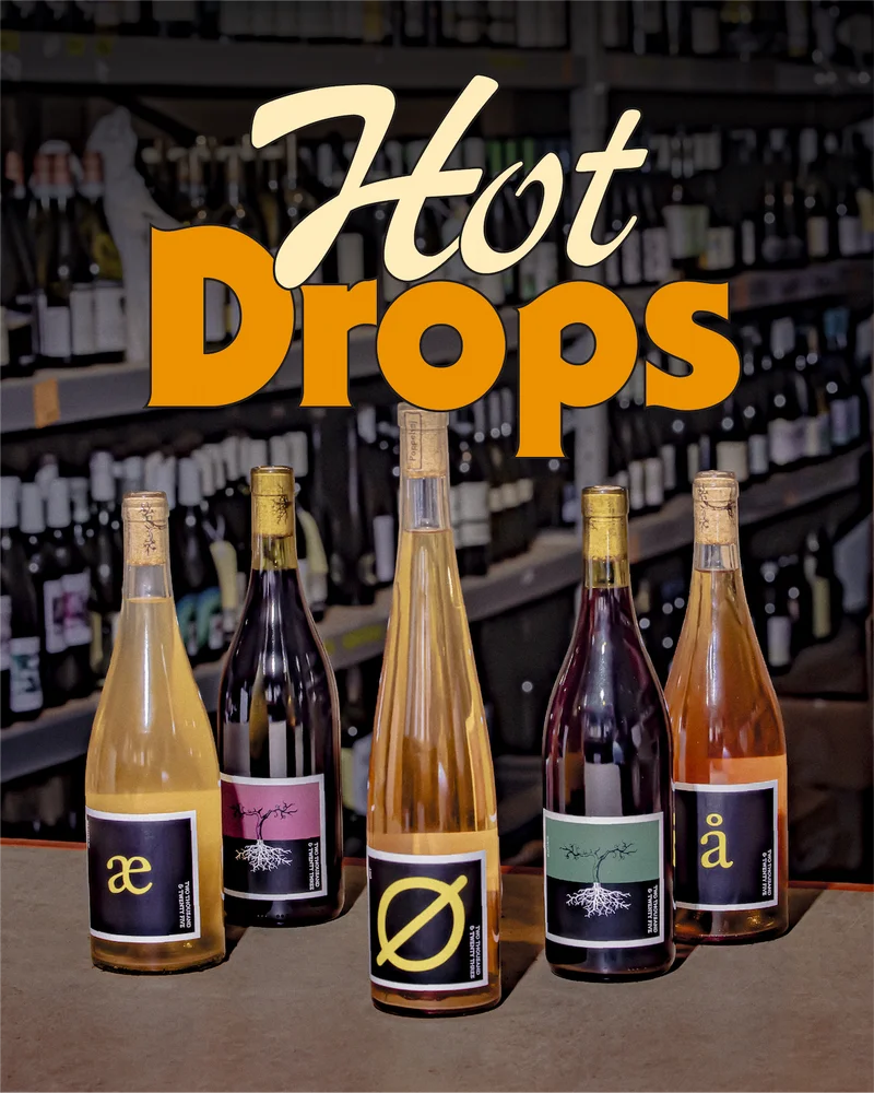 A sleek lineup of Poppelvej wines, the photo shot against a green background.