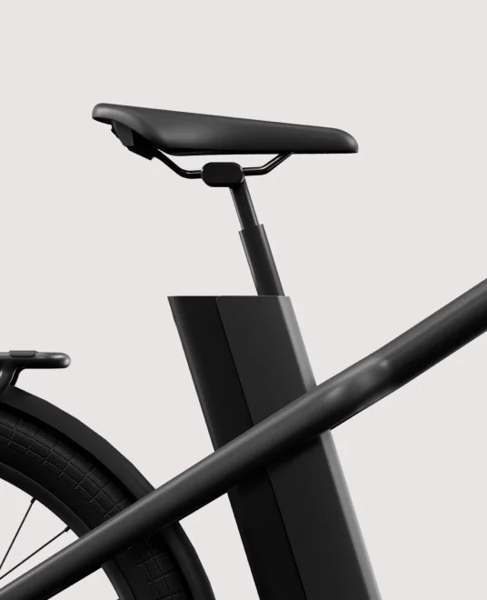 A render. Rear angled view of a Cowboy Cross ST e-bike with a cargo rack and integrated rear light.
