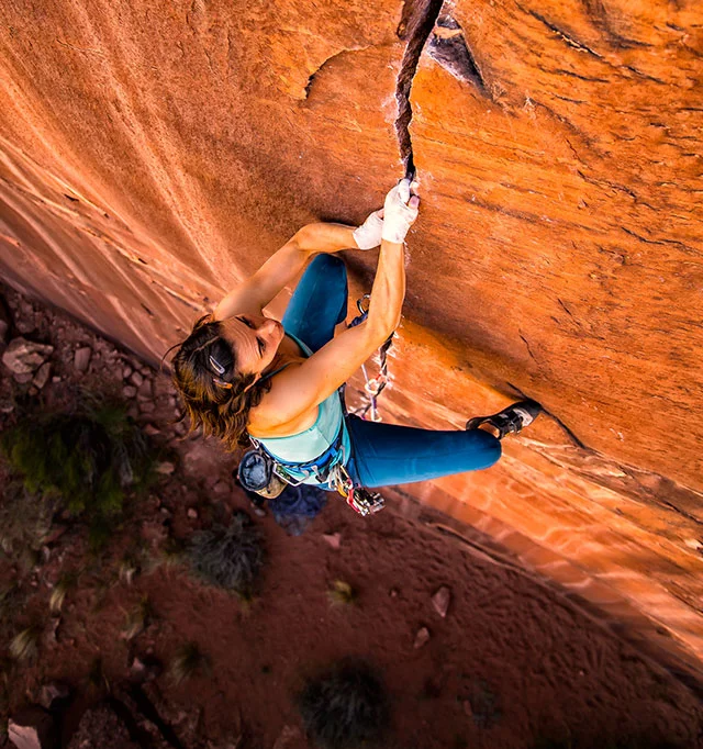 Pro climber Steph Davis climbing 'Hidden Gem' near Moab Utah. The athlete often experiences a flow state during her intensive free climbs.