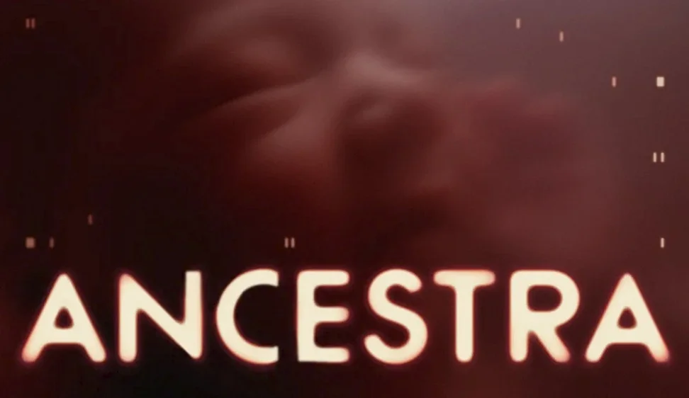 The word ANCESTRA in light orange capital letters is at the bottom of the image, set against a dark red, blurry background that suggests a face or abstract form, with small white digital elements scattered around.
