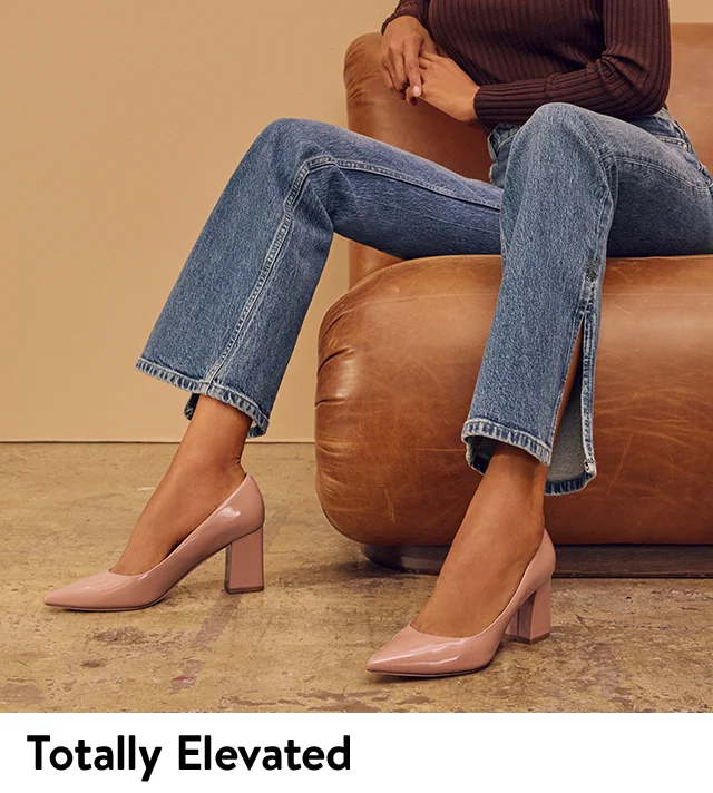 A woman wearing pointed-toe pumps with block heels.