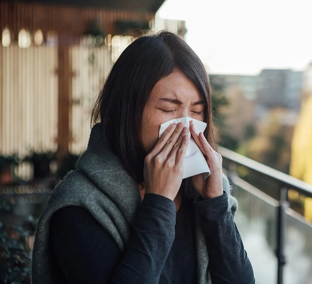 A woman blows her nose
