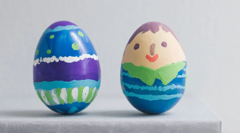 A collection of dyed Easter eggs with intricate patterns created by wrapping rubber bands around them before dyeing. The text reads, ''Rubber Band Eggs – Make beautiful designs with this egg-dyeing technique.''