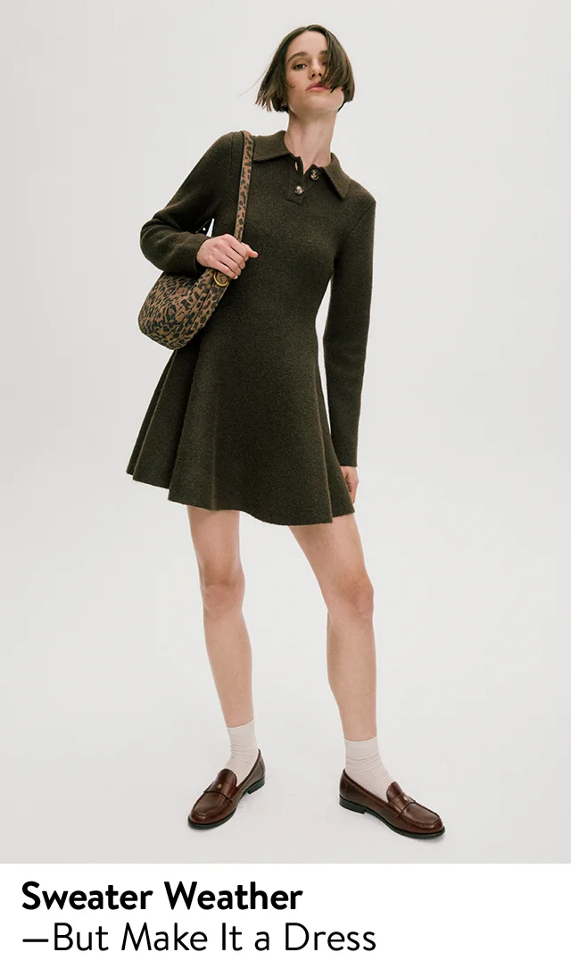 A woman wearing a sweater-dress with socks and loafers.