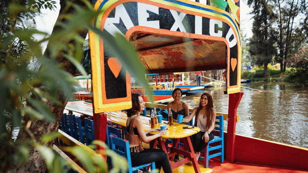 Image description: Girls on a boat in Xochimilco Gardens.