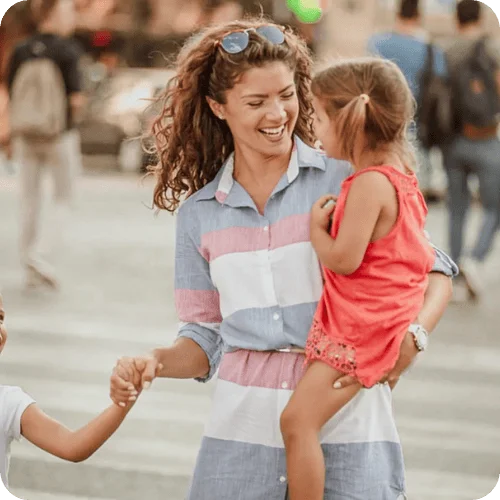 A smiling mom walking with her two little girls A smiling mom walking with her two little girls