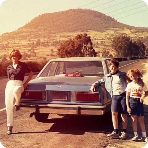 a family posing beside their car on a retro road trip a family posing beside their car on a retro road trip