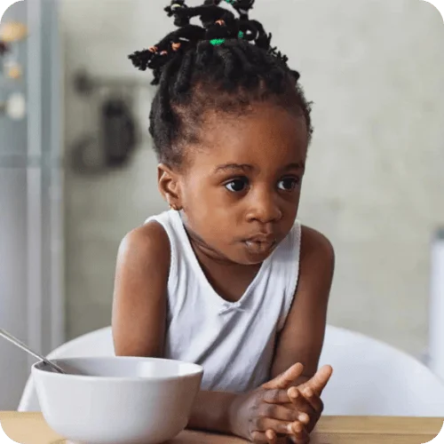 a little girl looking skeptical about her dinner a little girl looking skeptical about her dinner